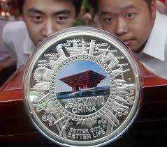 Customers take a close look at Shanghai World Expo-themed souvenir silver pan at a fair of licensed products at Shanghai International Exhibition Center, ... - Expo-themed%2520silver%2520bars%2520hit%2520the%2520market,%2520Shanghai%2520(3)