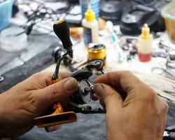 Image of technician repairing a fishing reel