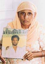 Gurpal Kaur holds the photograph of her husband, Balwant Singh, who was killed allegedly - ct3