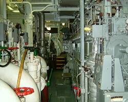 Image of ship's engine room with gaskets visible, and a porthole showing the ocean
