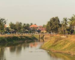 The calm Siem Reap River flanked by greenery.