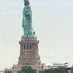Protester scales Statue Liberty's base,