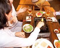 happy group enjoying yakiniku at a tableの画像