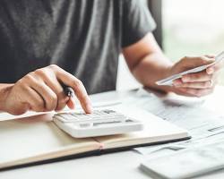 Image of person calculating costs on a calculator