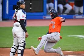 Cleveland Guardians catcher Bo Naylor, left, stands near home plate as Houston Astros' Christian Walker (8) scores in the fifth inning of a baseball game in Cleveland, Monday, April 20, 2026.