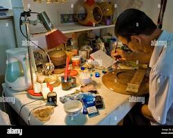 An artisan carefully shaping molten glass in a workshop.