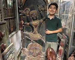 A Cambodian artisan carefully carving an intricate wooden design.