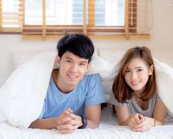 صورة couple in bed looking happy and satisfied