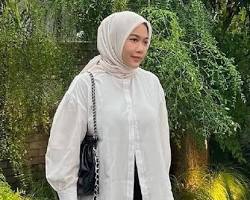 Gambar young woman wearing a semiformal hijab outfit with a pleated pashmina hijab, blouse, and dress pants