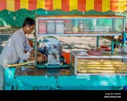 Image of Sugarcane juice being squeezed by a vendor in Cambodia