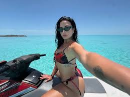 Demi Lovato pops up her butt in tiny thong bikini and shows off toned stomach while riding jet ski on tropical vacation