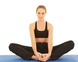 Persona sentada en el suelo realizando el estiramiento de mariposa para mejorar la flexibilidad de caderas y aductores.