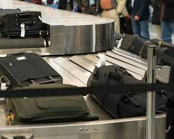 person putting their bags on a conveyor belt at an airport.