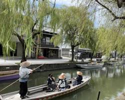 couple enjoying a relaxing boat ride on the Yanagawa River, surrounded by willow trees and traditional houses.の画像