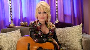 Dolly Parton performing with a guitar at Dollywood