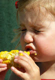 Menina de Litle que come a espiga de milho Foto de Stock. Menina de Litle que come a espiga de milho - menina-de-litle-que-come-espiga-de-milho-1172630