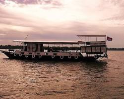 A beautiful wooden cruise boat on a Cambodian river at sunset
