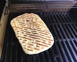 Imagine cu flatbread cooking on a hot griddle.