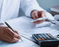 business owner looking at a tax form with a calculator in hand resmi