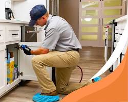 Image de pest control professional inspecting kitchen with flashlight discreet