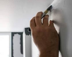 Image of professional painter meticulously cutting in edges with a steady hand