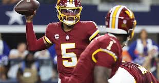 Washington Commanders quarterback Jayden Daniels leaving the field after an elbow injury