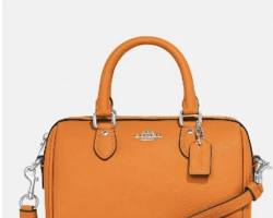 Image of mini leather crossbody bag in a vibrant neon orange color