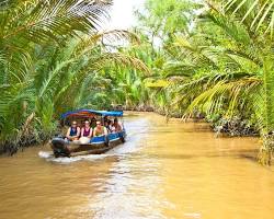 Image of boat cruising through the Mekong Delta in Cambodia, showcasing lush greenery, floating villages, and vibrant life on the water