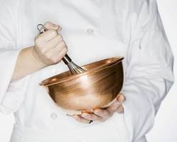 Image of chef whipping egg whites in a copper bowl