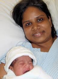 Million to one: Ravi Thangarajah cuddles her miracle baby daughter Durga who grew inside her ovary for almost nine months - article-1023057-016C8A7E00000578-302_468x634