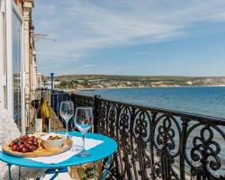 sunny apartment balcony Calella table view of tile roofs and sea, généré par IA