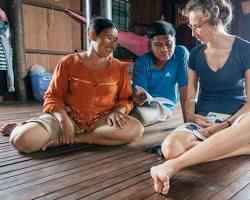 A traveler interacting with local Cambodians in a village
