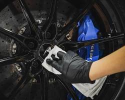 Image of car wheel being coated with a protective sealant