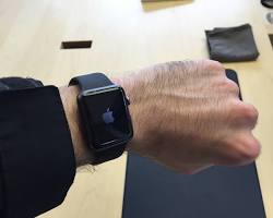 Image of man trying on different watches at a store