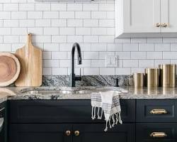 Image of kitchen with white upper cabinets and black lower cabinets