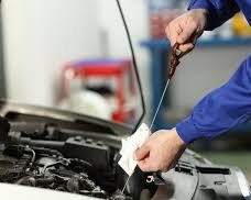 Image of mechanic checking oil level in a car