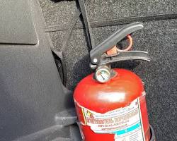 Изображение: Огнетушитель закреплен в держателе для огнетушителя на центральной консоли Opel Corsa
