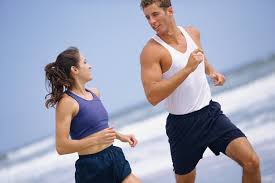 A man and woman running on the beach.