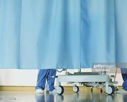 Image of Patient in hospital bed behind drawn privacy curtain