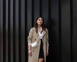 Image of model wearing an oversized trench coat over a mini dress.