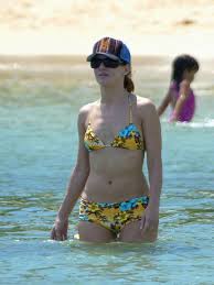 Mit ihre schlanke Körper und Braun schwarz Haartyp ohne BH (BH-Größe 34B) auf Strand im Bikini
