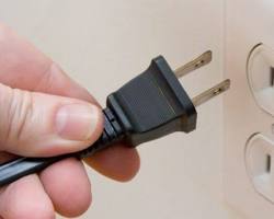 Image of hand unplugging a power cord from a Smart TV