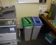 Image of copier machine with a recycling bin next to it