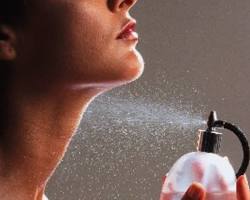 person spraying perfume on themselves